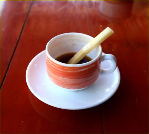 Coffie sweetened with a piece of sugarcane