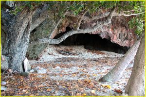 Cave on limited access island of Vanua Levu (Mamanuca chain, Fiji) with spiritual importance to indigenous tribe ("altar" under the tree on left)